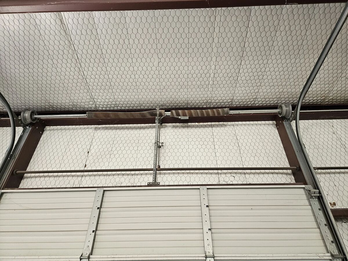 Torsion springs and track above a commercial sectional door