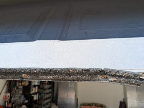 A worn bottom weather seal on a garage door