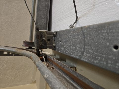 A garage door roller and bracket in the track