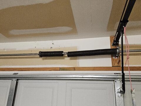 A broken torsion spring above a garage door