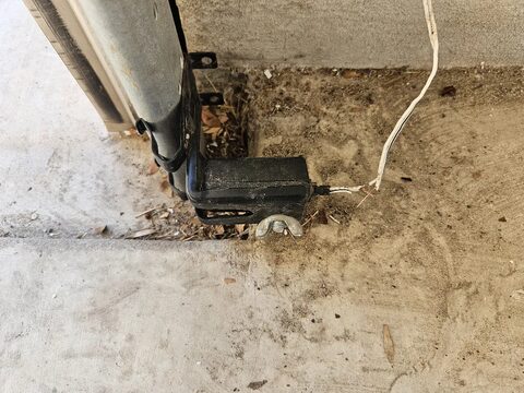 A garage door safety sensor at the bottom of the track
