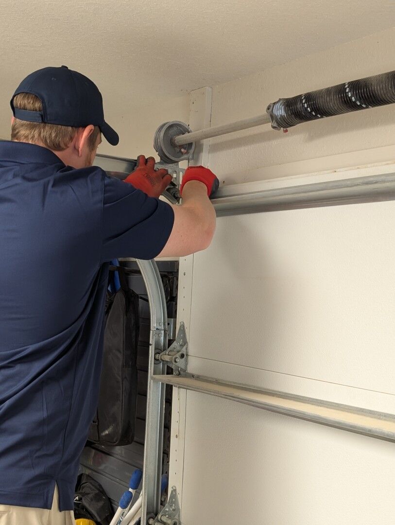 Howdy Garage Doors technician working on the torsion shaft and cable drum