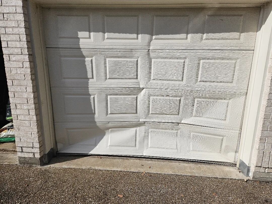 Garage door with dented and buckled panels