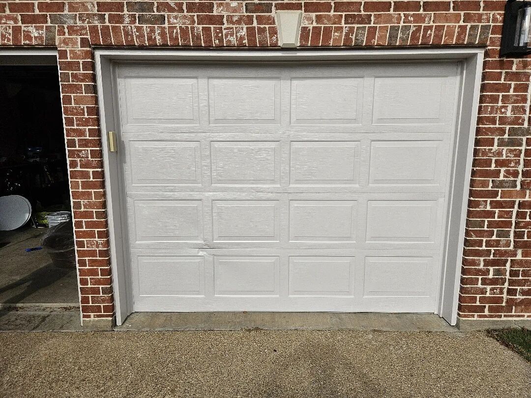 White garage door with a damaged panel