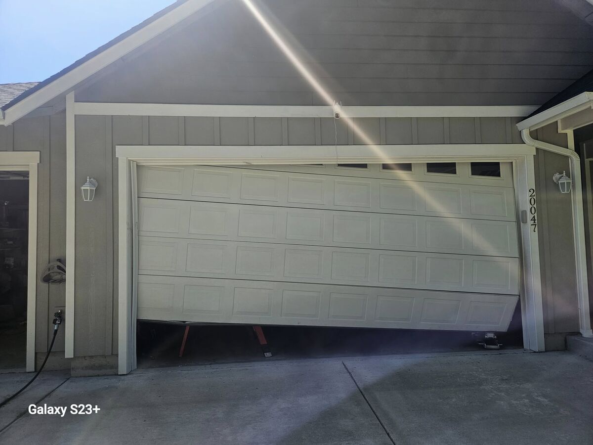 Garage door hanging off its track on one side