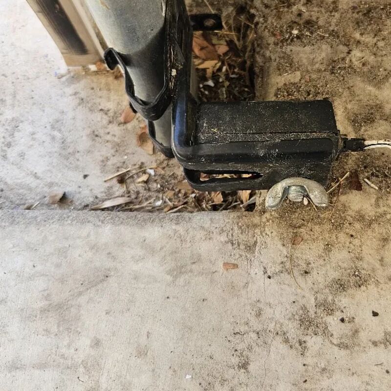 Close view of a garage door safety sensor near the floor