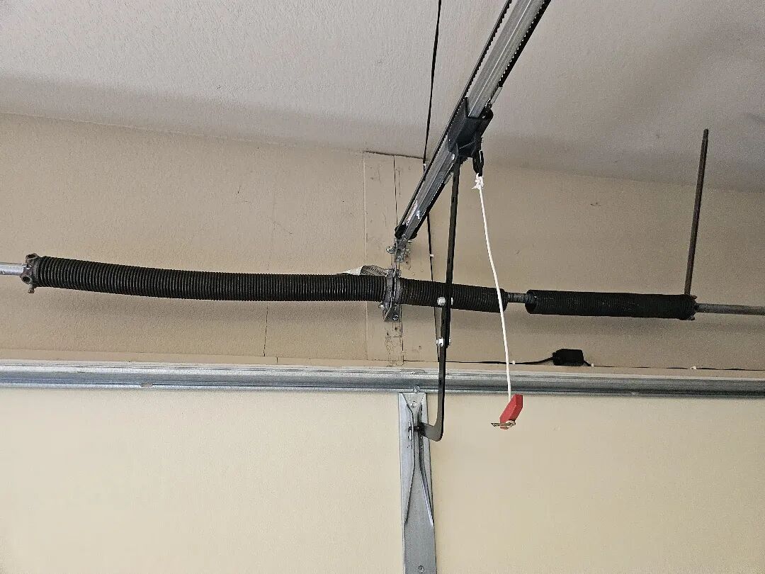 Torsion springs mounted on the shaft above a garage door opening